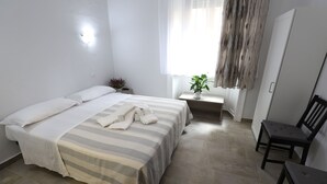 A bedroom with a bed, a bedside table with a plant, a chair, and a wardrobe. - Hotel Leonardo da Vinci (Milan)