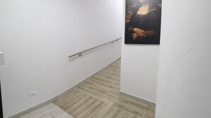 A hallway with a wooden floor, white walls, and a handrail. - Hotel Leonardo da Vinci (Milan)