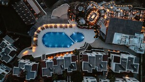 An aerial view of a resort with a central swimming pool, multiple lounge areas, and a variety of accommodations. - YAZ Yalikavak (Bodrum)