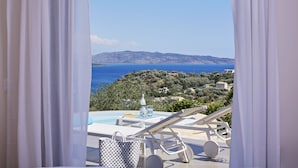 Un balcone con piscina, sedie a sdraio e vista sul mare e sulle colline.