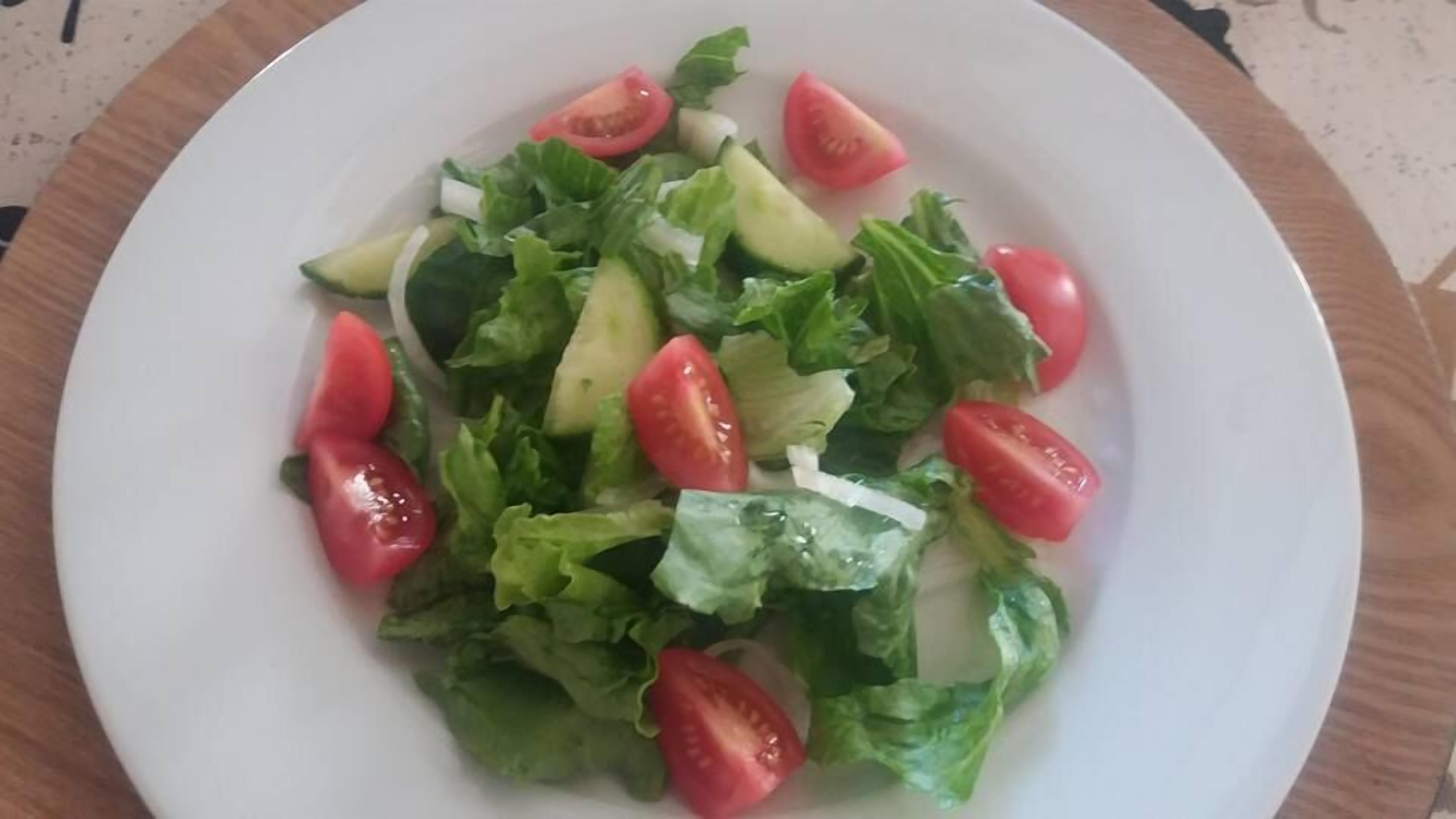 Een bord met een salade van sla, tomaten en komkommer.