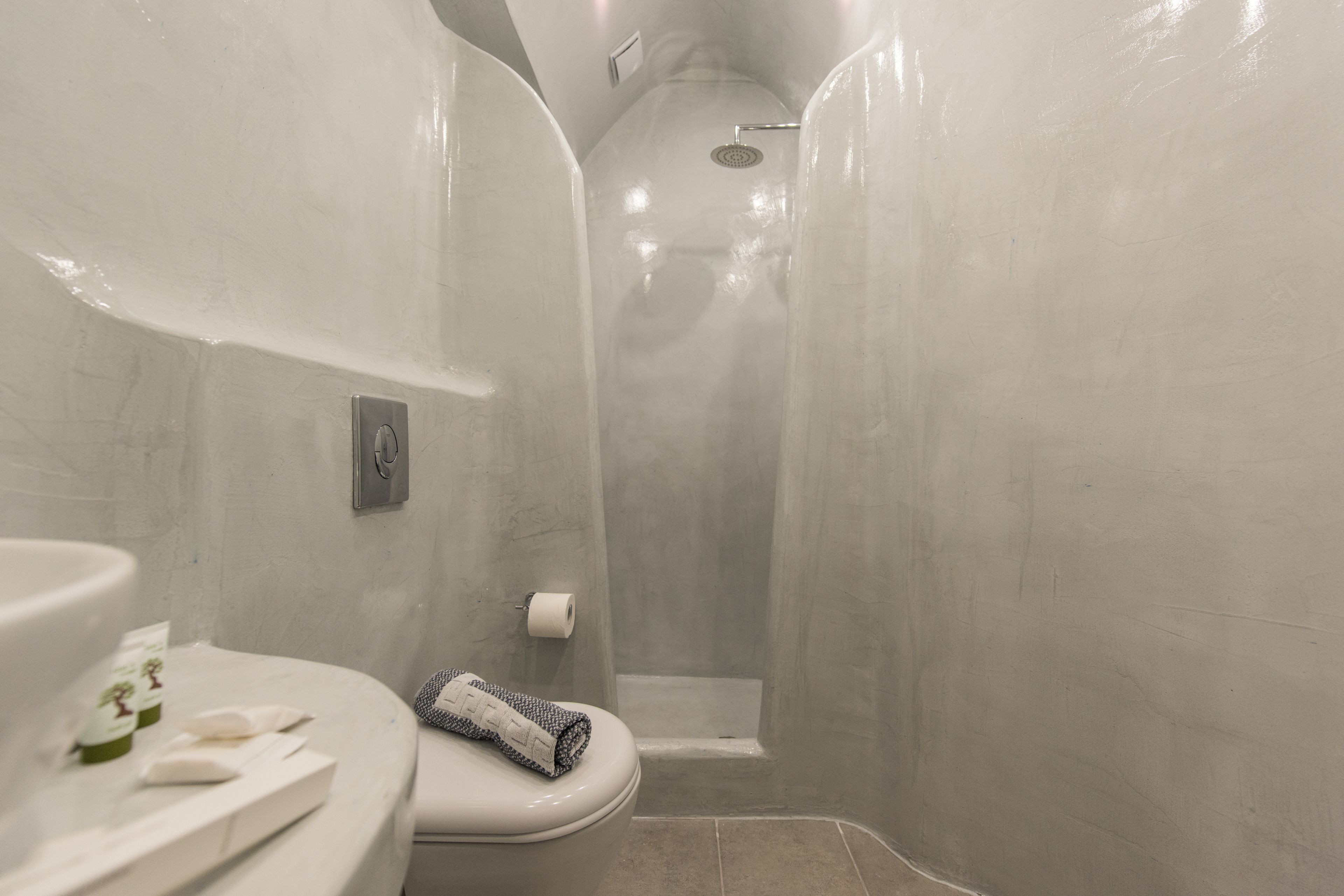 A bathroom with a toilet, a shower, and a sink.
