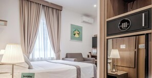 A hotel room with a bed, a chair, a desk, a lamp, and a minibar. - Residenza Scarlatti (Naples)