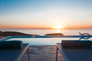 A sunset view from a balcony with two lounge chairs and a towel. - Villa Meli (Kea)