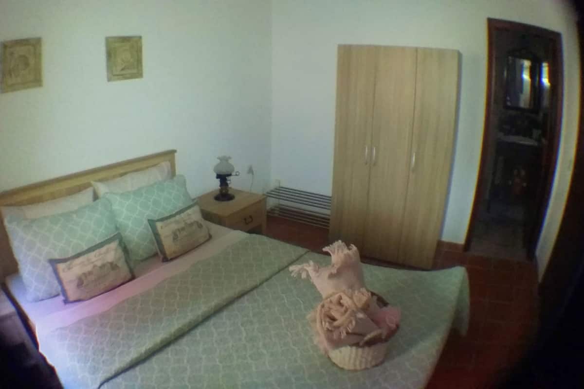 Ein Schlafzimmer mit einem Bett, einem Nachttisch, einem Kleiderschrank und einer Heizung.