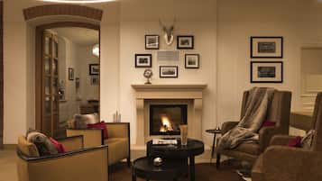 A cozy living room with a fireplace, comfortable seating, and framed pictures on the wall.
