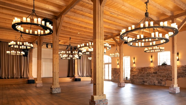 A spacious hall with wooden floors and multiple chandeliers. - Hotel Brunnenhaus Schloss Landau (Bad Arolsen)