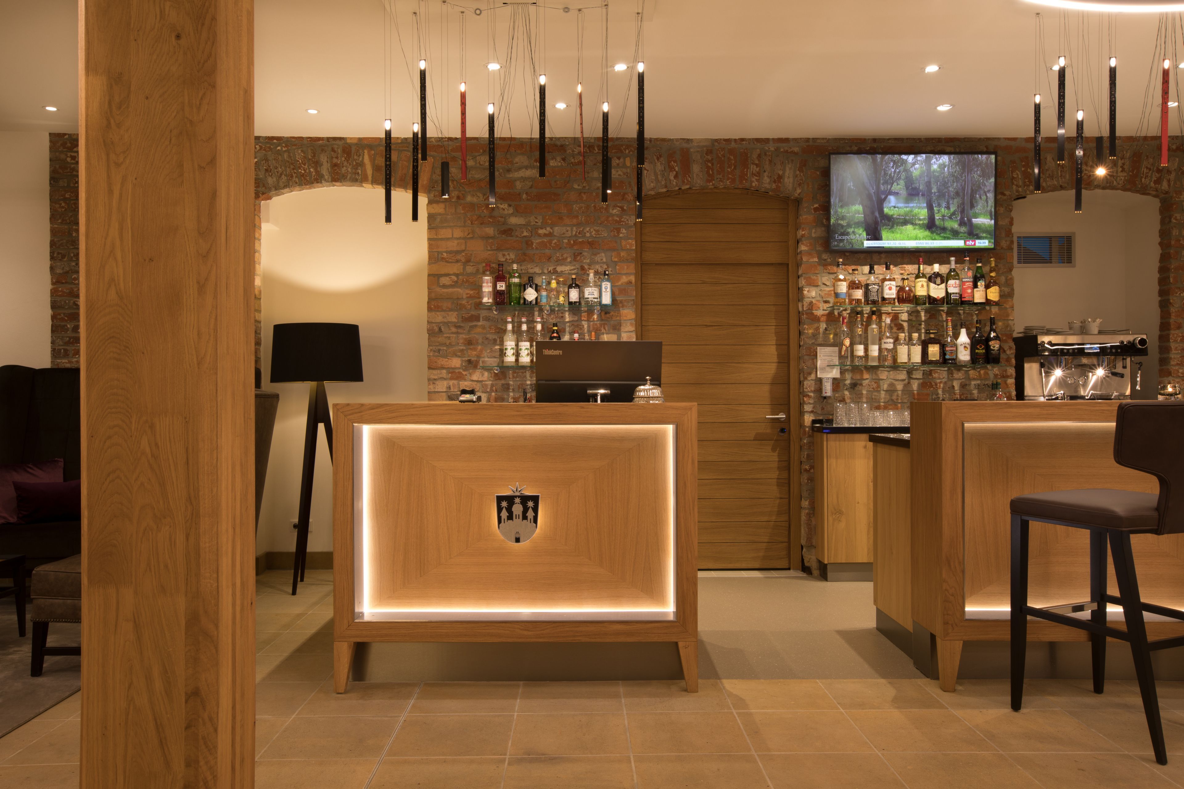 Un espace bar avec des meubles en bois, un téléviseur et une variété de bouteilles.