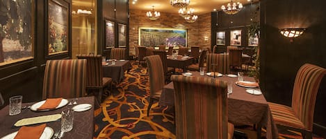 Un restaurante con varias mesas, sillas y piso alfombrado.