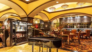 Un magnifique piano à queue dans un espace bar luxueux, avec un comptoir et des sièges.