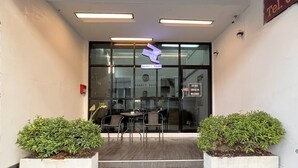 A building entrance with a sign for 'Rabbit Room,' a staircase, and two potted plants.