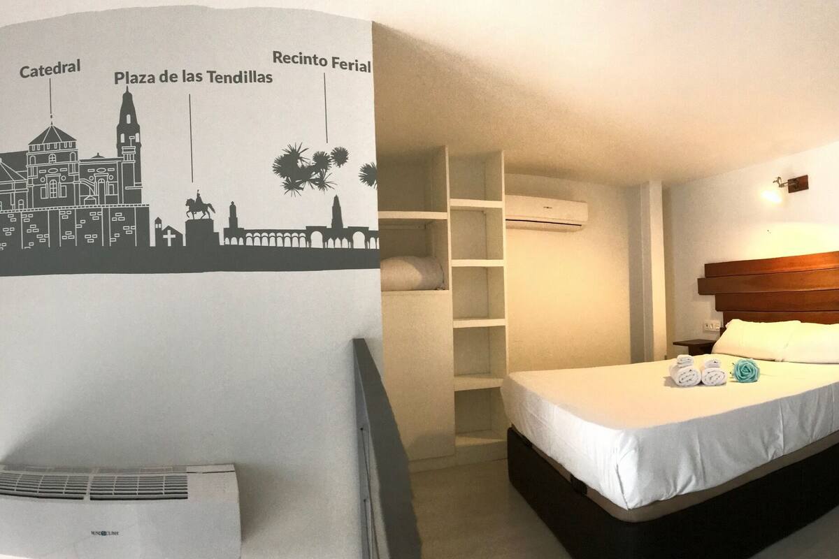 Ein Hotelzimmer mit einem Bett, einer Wand-Klimaanlage und einer Stadtkarte.