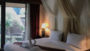 A hotel room with a bed, a nightstand with a lamp, a window with curtains, and a view of the outside. - The Imperial Home Hotel (Bangkok)