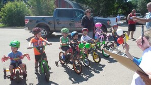 Children riding bicycles in a parking lot.