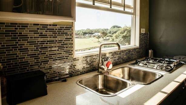 A kitchen with a window, a sink, and a stove.