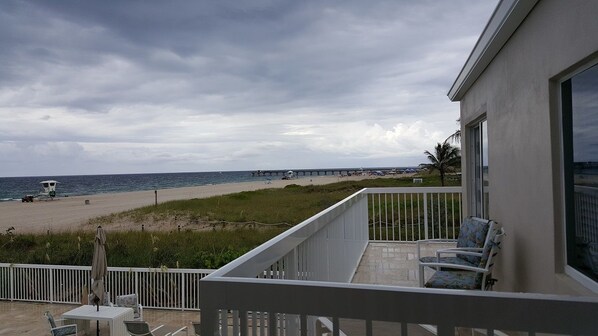 A balcony with a view of the beach and ocean, a lifeguard tower, and a pier in the distance. - Le Cabanon Motel (Pompano Beach)