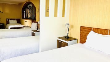 Una habitación de hotel con dos camas, un cabecero de madera, una mesita de noche con lámpara y un espejo.