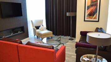 Una sala moderna con un sofá, un sillón y una mesa redonda de centro.