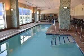 Relax by the pool surrounded by a decorative mosaic and lounge chairs.