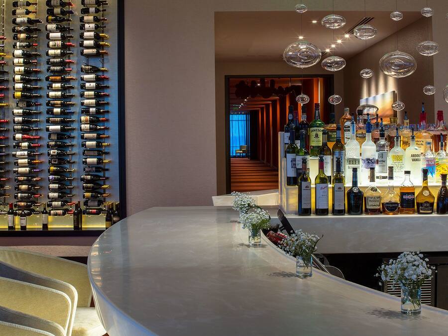 A bar area with a wine rack, a bar counter, and hanging lights.