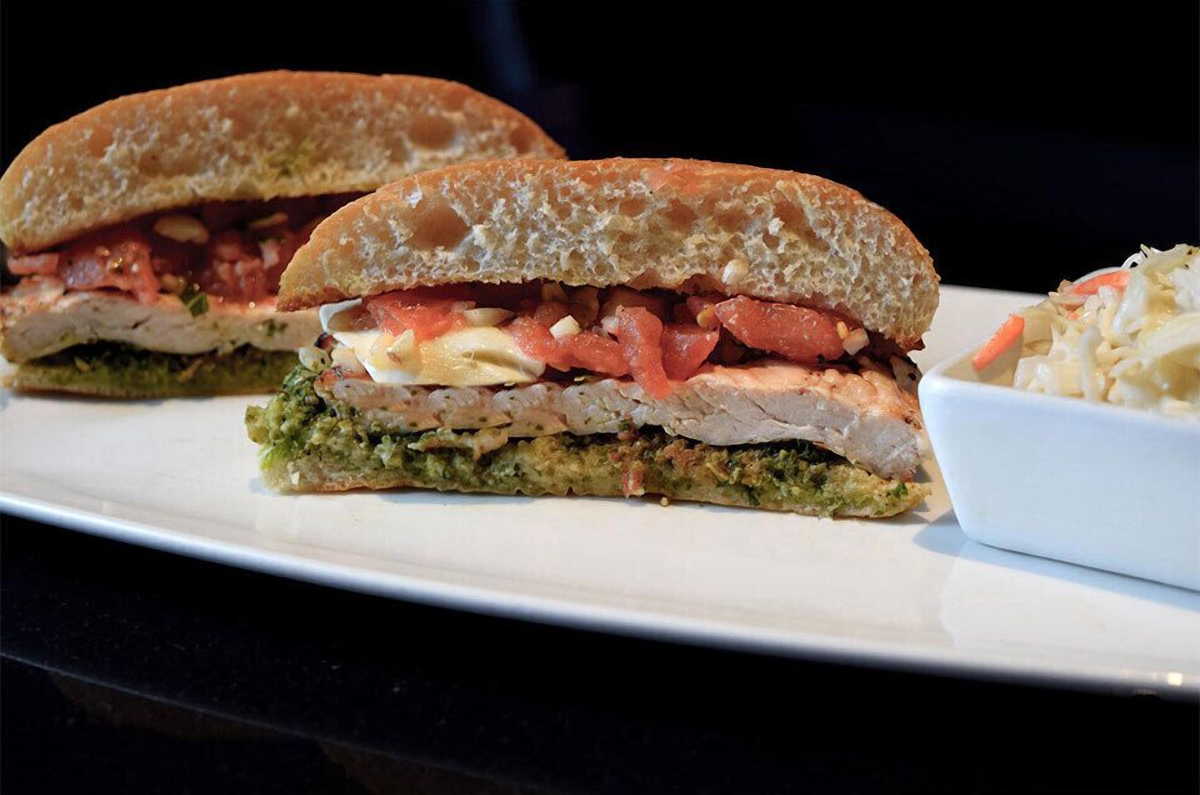Un sándwich con varias capas y una guarnición de ensalada de col.