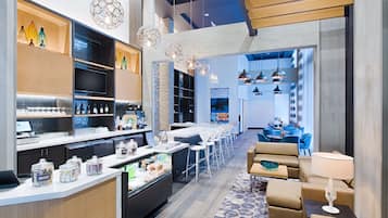 Welcome to our hotel lobby, featuring a central reception area, comfortable seating, and a dining space.