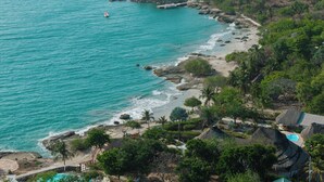 A coastal resort with a beach, palm trees, and a pool. - Hotel Isla Real (Cartagena)
