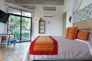 A bedroom with a bed, a TV, a window, and a wall-mounted air conditioner. - Hotel Isla Real (Cartagena)