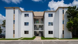 Un edificio moderno de dos pisos con una entrada central, ventanas amplias y techo plano.