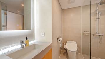 Een moderne badkamer met douche, toilet en wastafel.