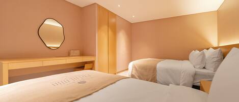A hotel room with a bed, a bedside table, a mirror, and a wardrobe.