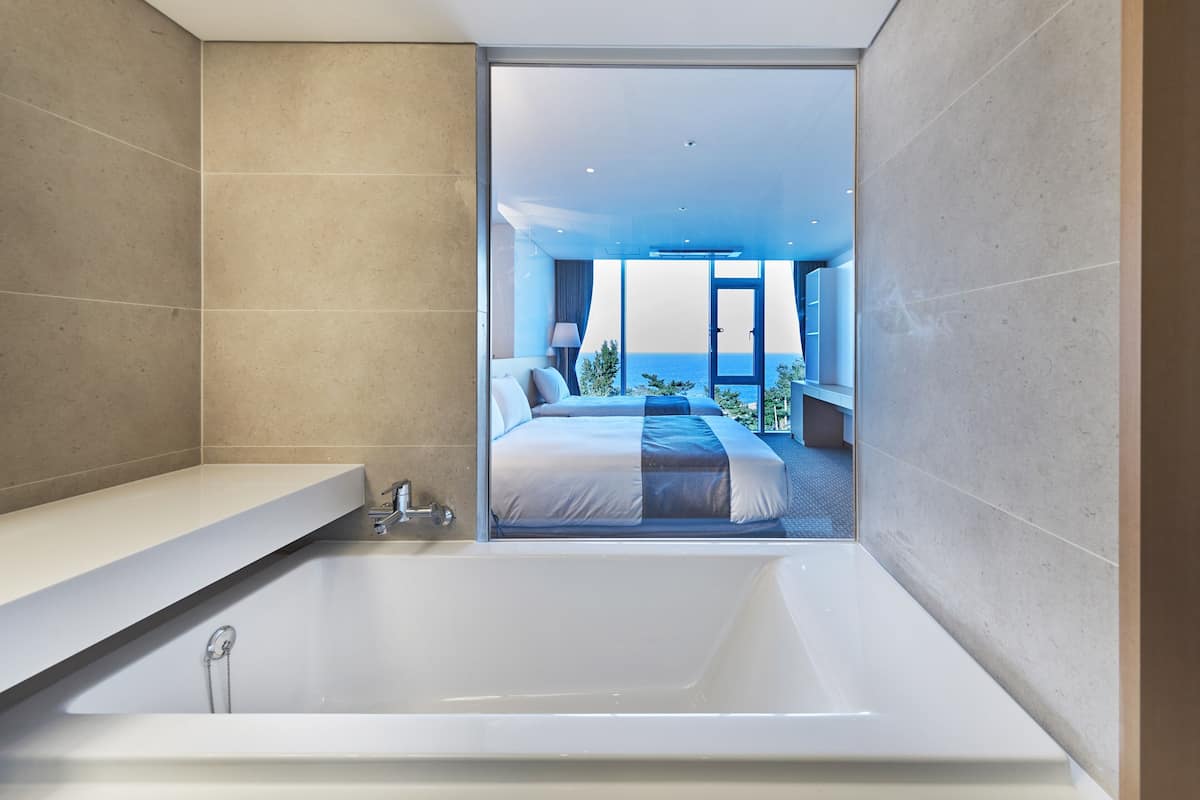 deluxe twin ocean view | bathroom | shower, eco-friendly toiletries, hair dryer, slippers