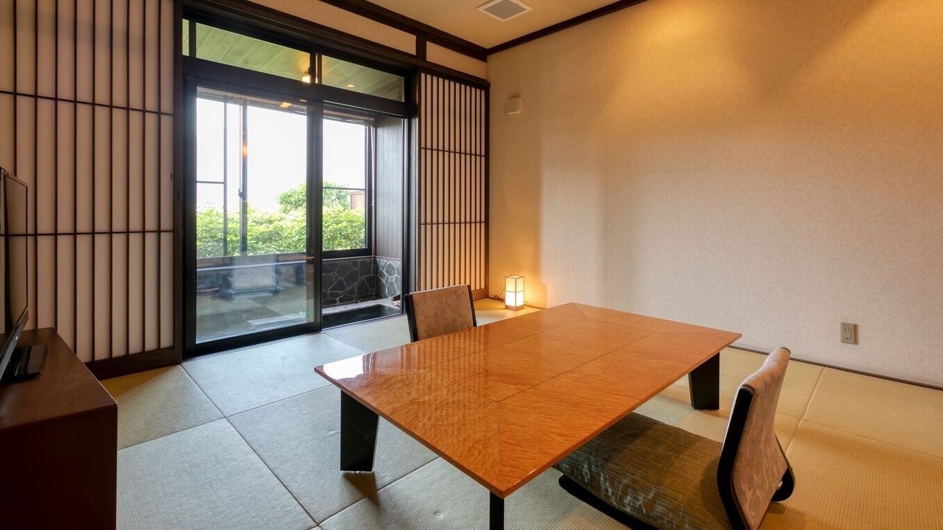 A traditional Japanese room with tatami flooring, a low table, and sliding doors.
