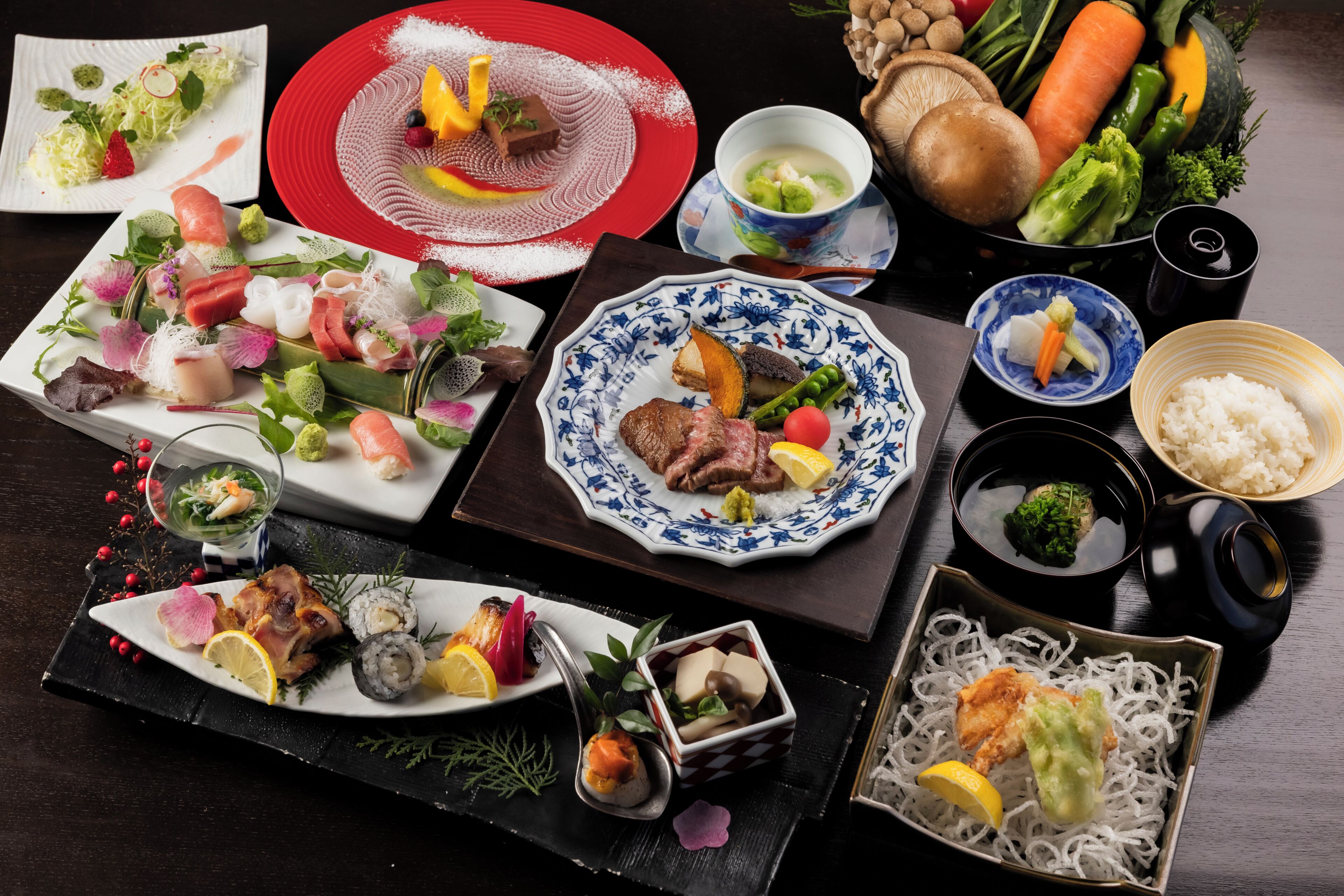 A variety of dishes on a table, including sushi, sashimi, and a bowl of soup.