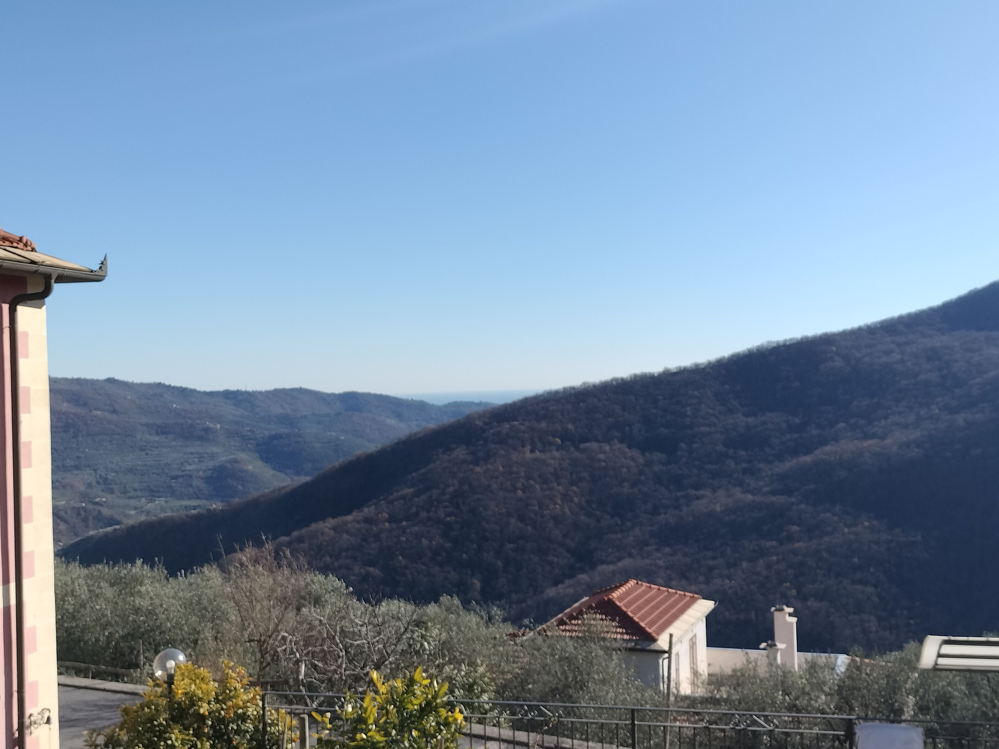 A mountainous landscape with a building featuring a red-tiled roof.