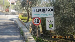 A street sign for Lucinasco, a village ideal for Italy, with a speed limit sign of 30.