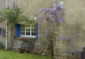 A rustic stone building with a window featuring blue shutters. - Rural peaceful house close to beach, golf and shops. House sleeps 7/9. (Grezac)