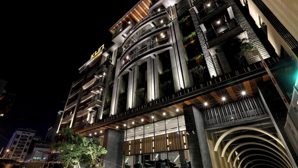Un hôtel à plusieurs étages doté de balcons, de grandes fenêtres et d’une architecture moderne.