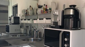 A modern kitchen with stainless steel appliances, a coffee maker, and a microwave. - Charming mazet for 4 pers. 33m2 swimming pool (Saint-Paul-De-Vence)