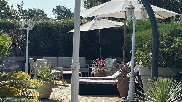 A poolside area with a wooden deck, lounge chairs, and potted plants. - Charming mazet for 4 pers. 33m2 swimming pool (Saint-Paul-De-Vence)