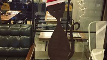 A restaurant interior with a large window, leather seating, and a decorative Santa hat on a sculpture.