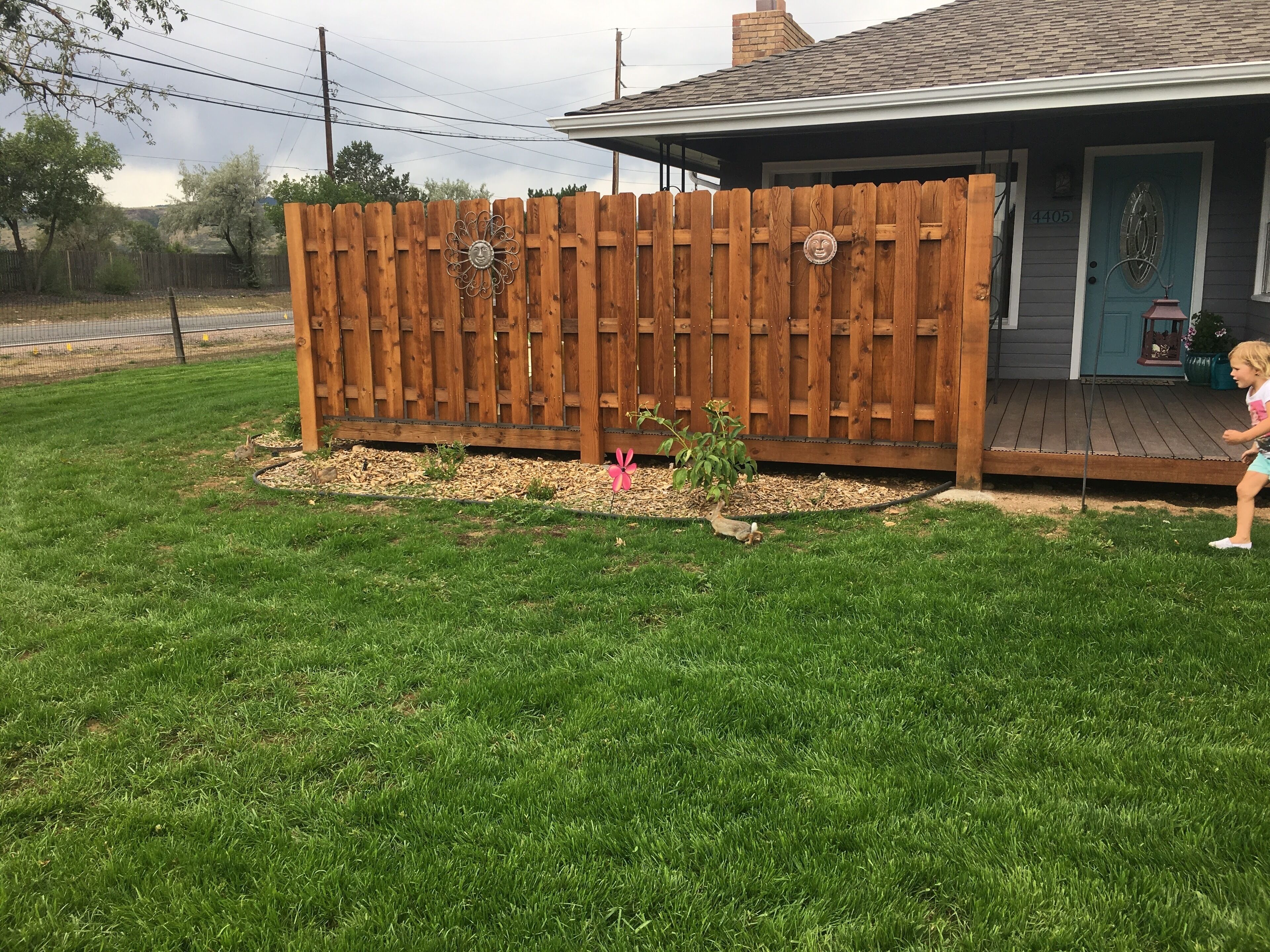 Un patio cercado con una terraza de madera y el número 4405.