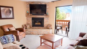 A living room with a fireplace, leather armchairs, a sofa, and a wooden coffee table. - Remodeled Townhome in Excellent Location.Pool &Gym (Frisco)