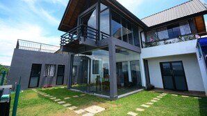 A modern two-story house with large glass windows and a balcony. - Mount Lake Inn (Nuwara Eliya)