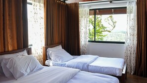 A room with two beds, wooden ceiling, and a window with curtains. - Mount Lake Inn (Nuwara Eliya)