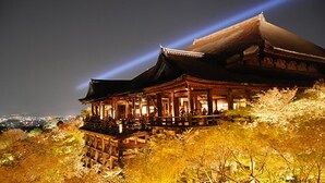 A traditional Japanese building with a prominent sloped roof and wooden structure, surrounded by autumn foliage. - KIZASHI THE SUITE (Kyoto)