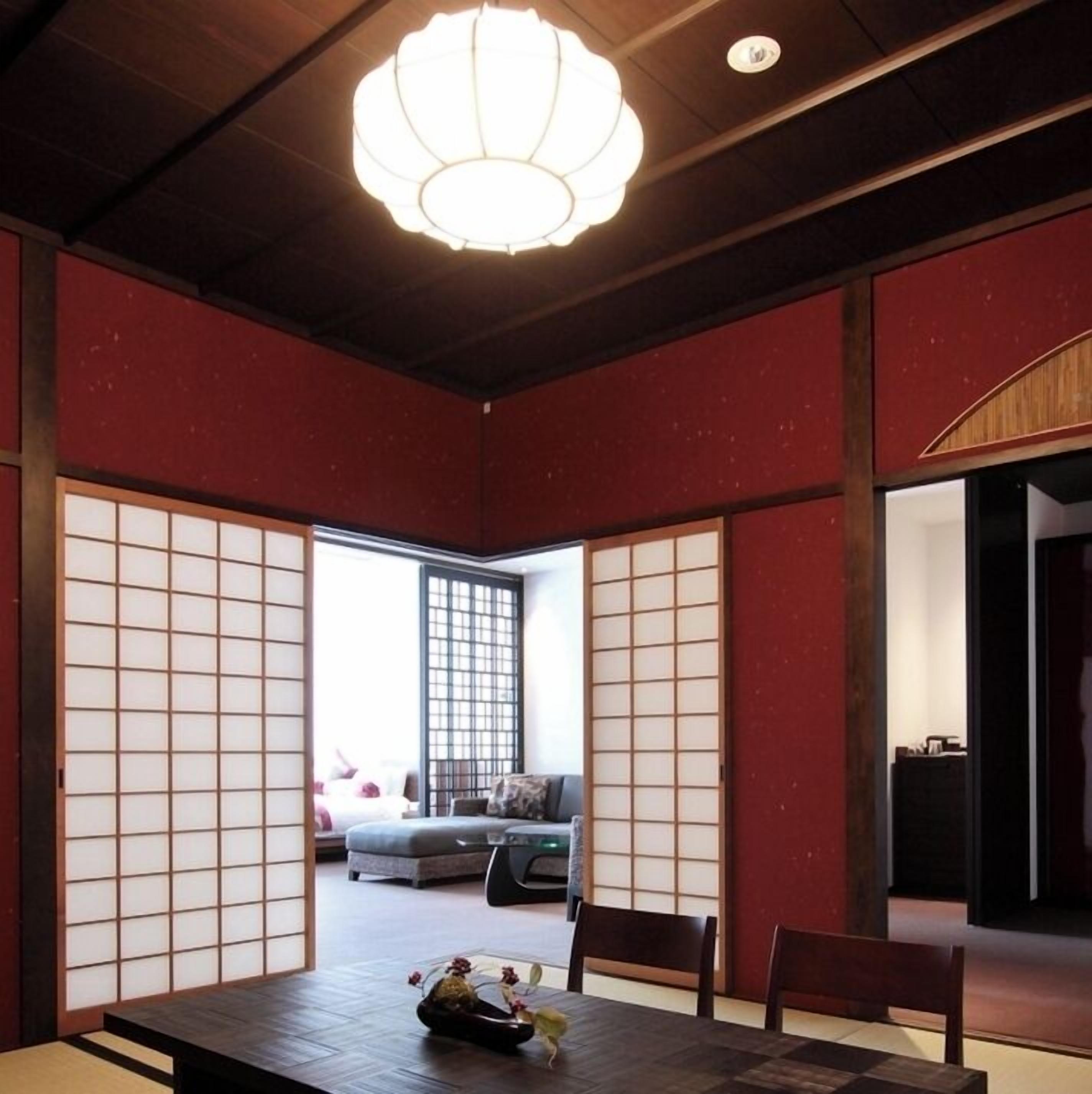 A traditional Japanese room with tatami flooring, shoji screens, and a modern chandelier.