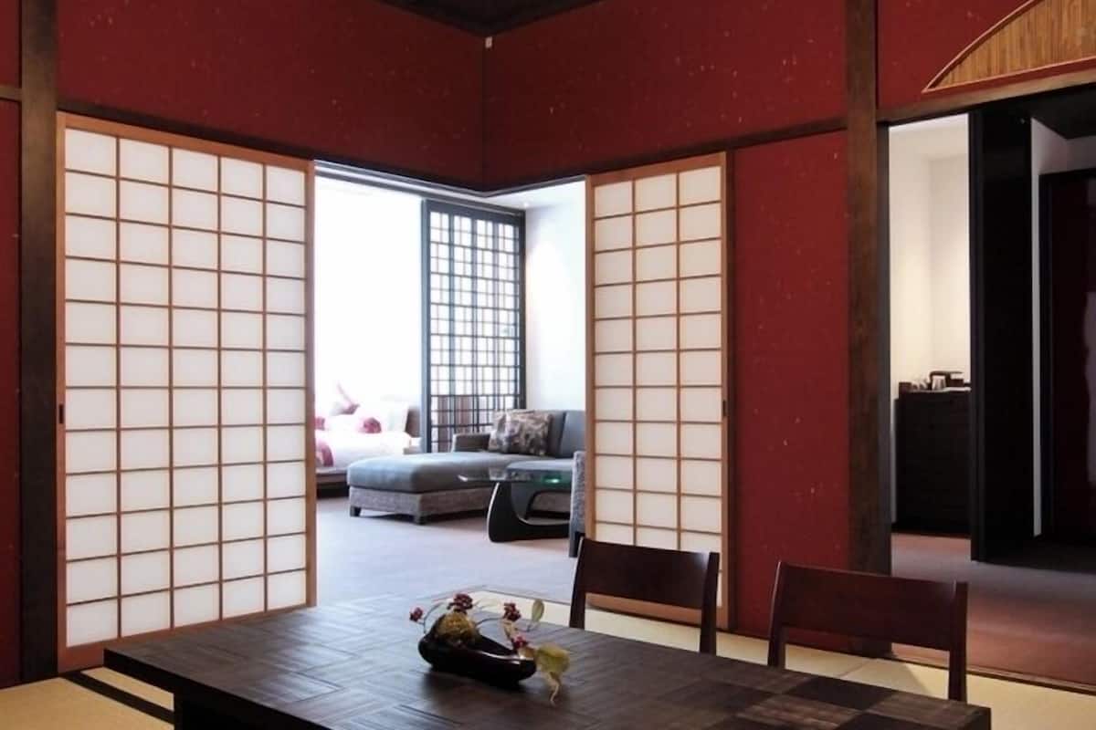 Une pièce de style japonais traditionnel, avec un sol recouvert de tatamis, des paravents shoji et un lustre moderne.