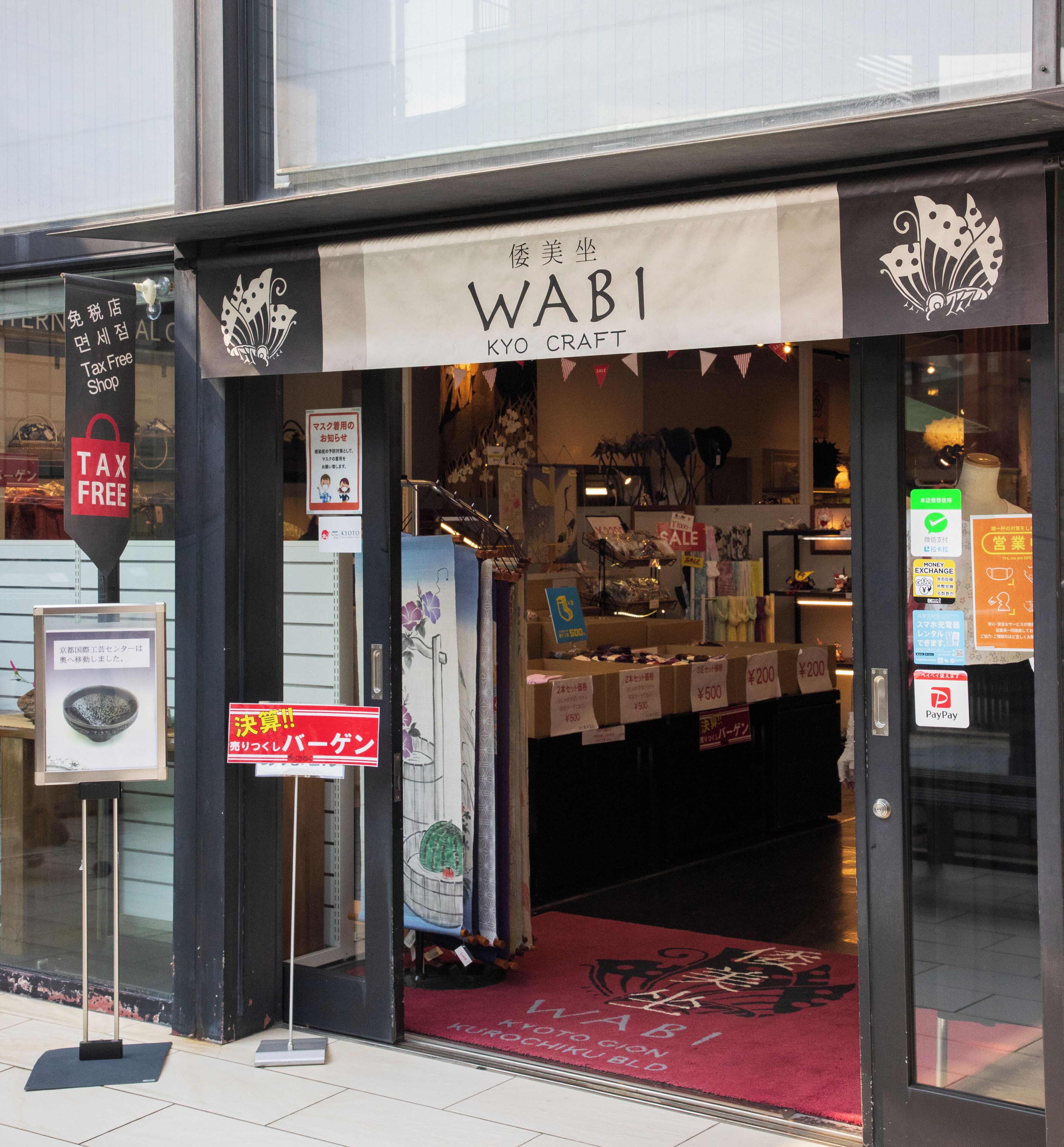 A storefront with a sign reading "WABI KYO CRAFT" and various items displayed outside.