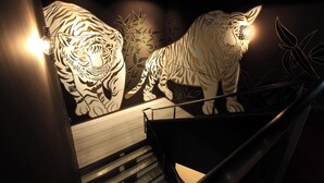 A staircase with a wall art of two white tigers. - KIZASHI THE SUITE (Kyoto)
